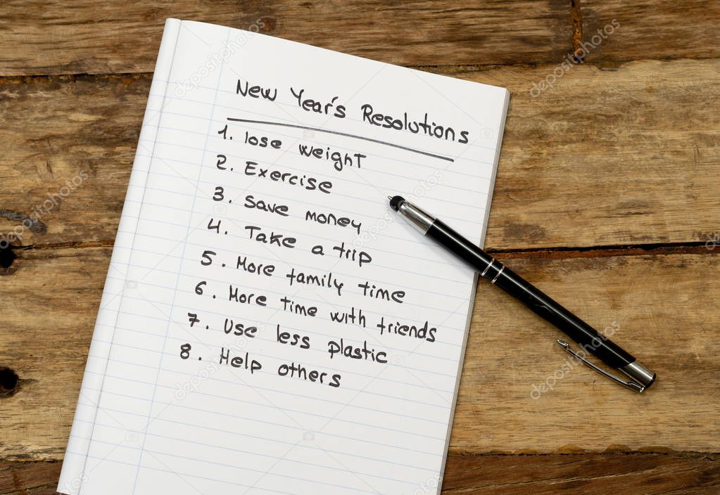 Top View 2019 New year resolutions list with wishes for new lifestyle written on notepad and pen on Vintage table in Wish list and Goals for happiness Aspiration and Motivation Concept.