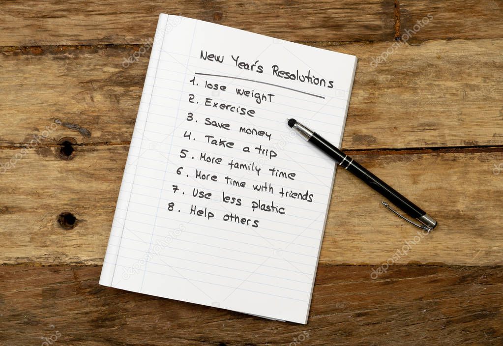 Top View 2019 New year resolutions list with wishes for new lifestyle written on notepad and pen on Vintage table in Wish list and Goals for happiness Aspiration and Motivation Concept.