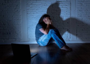 Stalker ya da umutsuz ve siber zorbalık ve sosyal medya kavramı içinde aşağılanmış hissediyor dedikodu tarafından cyberbullying ve çevrimiçi varlık taciz acı dizüstü bilgisayar ile ciddi bir şekilde perişan genç erkekler istismar.