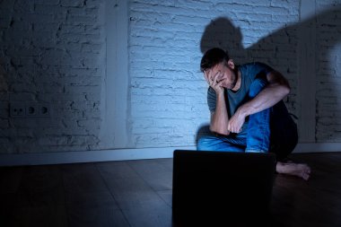 Stalker ya da umutsuz ve siber zorbalık ve sosyal medya kavramı içinde aşağılanmış hissediyor dedikodu tarafından cyberbullying ve çevrimiçi varlık taciz acı dizüstü bilgisayar ile ciddi bir şekilde perişan genç erkekler istismar.