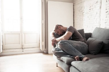 Mutsuz depresif beyaz erkek oturma ağlıyor ve oda kanepe duygu umutsuz bir yalnız vurguladı yaşayan yalan iş işsizlik anksiyete kalbi kırık ve depresyon üzüntü kavramı