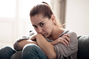 Genç çekici latin kadın evde oturma odası kanepe üzgün yalan yorgun ve ruh sağlığı, sorunları duygusal acı ve kırık kalp kavramı depresyon acı endişeli.