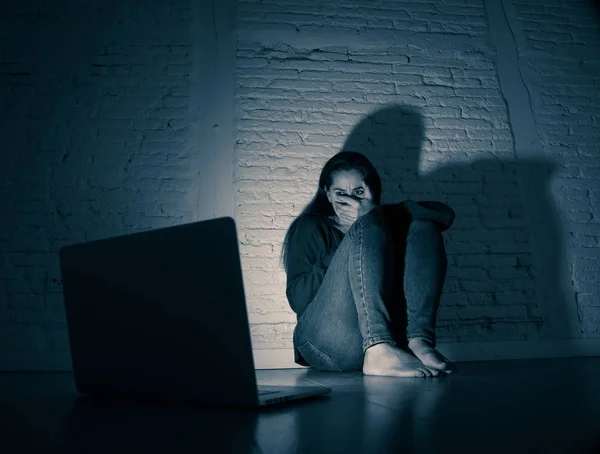 Sad and scared female Young woman with computer laptop suffering cyberbullying and harassment being online abused by stalker or gossip feeling desperate and humiliated in cyber bullying concept.