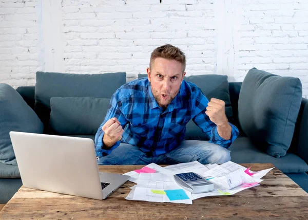 Worried and stressed man calculating bills tax expenses and counting home and business finances sitting on the couch at home in paying off debts and domestic bills and financial problems concept.