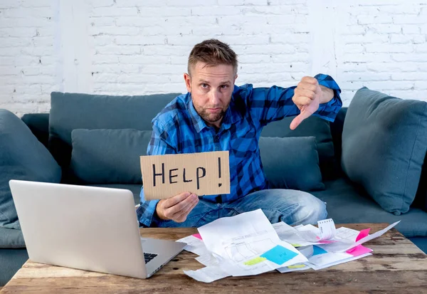 Worried and stressed man calculating bills Tax expenses and counting home finances sitting on couch in living room at home in paying off debts and domestic bills and financial problems concept.