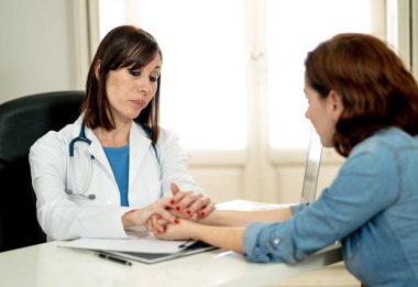 Kadın doktor güven verici ve onu teselli empati hastane Office ile ortaklık güven için tıbbi etik, kötü haber ve sağlık destek kavramı kadın hasta ile tanı tartışıyor.