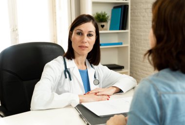 Çalışma ve sağlık profesyonelleri ve sağlık sigortası reklam kavramı da hastane klinik office odasında hasta ile bir Danışma sahip ciddi profesyonel kadın doktor portresi.