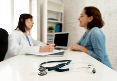 Close up image of stethoscope on out of focus doctor and patient talking in hospital clinic office background in Health care Insurance and Medical concept.