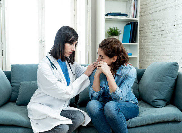 Female doctor comforting depressed crying woman patient sitting devastated at hospital private office after hearing serious disease diagnose or bad news in Health care support and trust concept.
