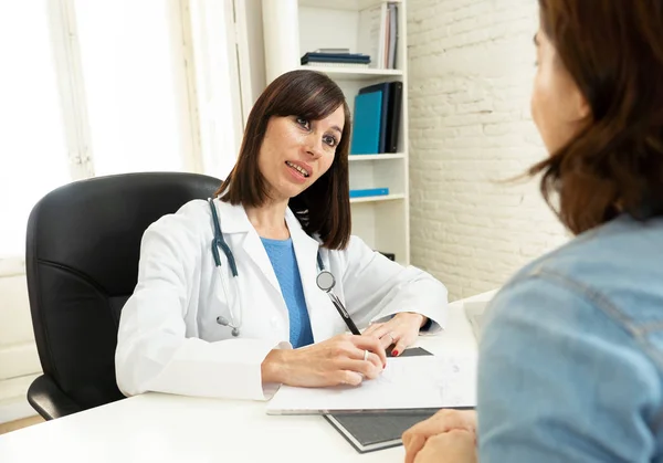 Smiling female doctor and happy patient talking and consulting in hospital clinic office in Health care, professional medical staff, happy hospital environment, Insurance and Medical trust concept.