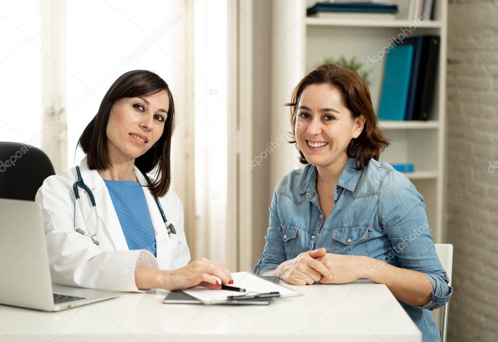 Smiling female doctor and happy patient talking and consulting in hospital clinic office in Health care, professional medical staff, happy hospital environment, Insurance and Medical trust concept.