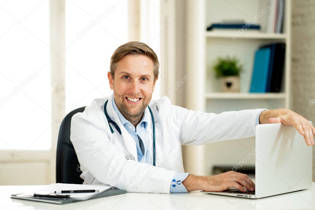 Portrait of happy caucasian doctor in white coat working on laptop computer and paperwork in clinic hospital desk for Health care successful professionals and Medical insurance advertisement.