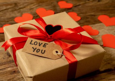 Hediye, kırmızı kalpler sunmak ve ahşap antika arka plan stilini Sevgililer günü dekorasyon, evlilik yıldönümü kutlama anneler ve babalar günü tebrik kartı ve aşk kavramı üzerinde mesaj seviyorum.