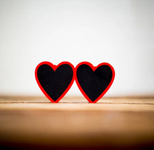 两个红色的心在复古质朴的木桌和浪漫的光与背景失去了焦点在情人节 母亲父亲的日子和婚礼贺卡的概念 复制消息的空间 — 图库照片