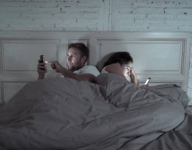 Teknoloji bağımlılığı birbirlerine ilgisizlik ve ilişki sorunları ve mobil internet bağımlılığı karanlıkta gece geç saatlerde akıllı telefonlarını kullanarak yatakta yatan öfke görmezden tarafından etkilenen çift.