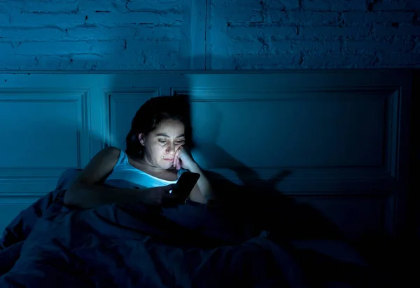 インターネット中毒若い美しい女性チャットと眠そうな彼女のスマート フォンを使用してインターネット上でサーフィン退屈して携帯依存症と不眠症概念で夜遅く疲れ — ストック写真