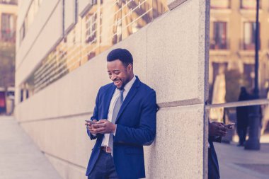 Genç adam akıllı aşınmaya üstünde hareket eden telefon açık havada city adlı metin e-posta ya da sosyal medya app sokak gönderme. Mutlu iş adamları, girişimci ve iş özgürlük iletişim teknoloji dışında çalışma.