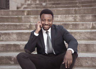 Akıllı cep telefonunda kentsel merdiven sokak şehir dışında mutlu konuşurken çekici iş adamı. İnsanlar, sosyal ağ, özgürlük, modern teknoloji ve girişimci yaratıcı iş kavramı.