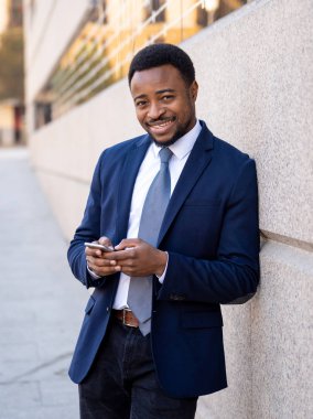 Genç adam akıllı aşınmaya üstünde hareket eden telefon açık havada city adlı metin e-posta ya da sosyal medya app sokak gönderme. Mutlu iş adamları, girişimci ve iş özgürlük iletişim teknoloji dışında çalışma.