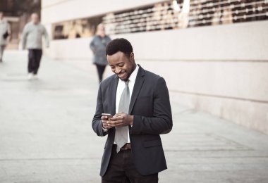 Genç adam akıllı aşınmaya üstünde hareket eden telefon açık havada city adlı metin e-posta ya da sosyal medya app sokak gönderme. Mutlu iş adamları, girişimci ve iş özgürlük iletişim teknoloji dışında çalışma.