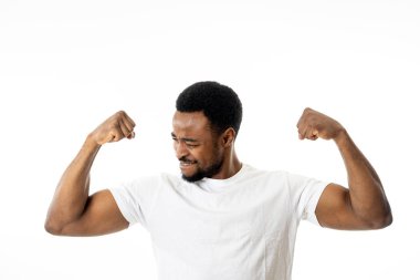 Genç güçlü yakışıklı Afrikalı-Amerikalı adam gösterilen silah kasları gururlu gülümseyen insanlar, mutluluk, Fitness, başarı insan duyguları ve yüz ifadeleri kavramı eğleniyor.