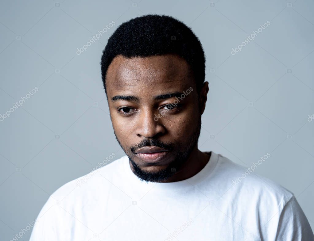 Portrait of attractive man sad and depressed suffering depression feeling sorrow and unpleasant pain in human emotions facial expressions and depression concept. Isolated on grey blue background.