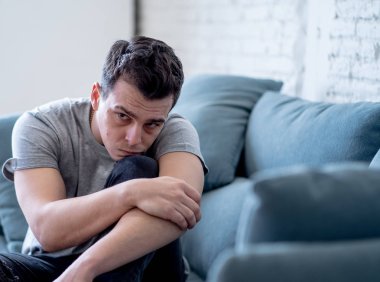Mutsuz depresif beyaz erkek ağlama ve umutsuz hissediyorum oturma odası koltukta yalan oturan vurguladı yalnız bir iş, işsizlik, anksiyete kalbi kırık ve depresyon üzüntü kavramı.