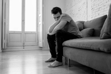 Mutsuz depresif beyaz erkek ağlama ve umutsuz hissediyorum oturma odası koltukta yalan oturan vurguladı yalnız bir iş, işsizlik, anksiyete kalbi kırık ve depresyon üzüntü kavramı.