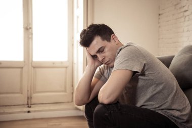 Mutsuz depresif beyaz erkek ağlama ve umutsuz hissediyorum oturma odası koltukta yalan oturan vurguladı yalnız bir iş, işsizlik, anksiyete kalbi kırık ve depresyon üzüntü kavramı.