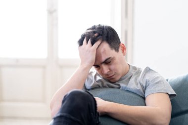 Depresyonda ve umutsuz tek başına eve acı duygusal acı ve mutsuzluk kanepe ağlıyor felling genç adam portresi. İnsanlar kırık kalp içinde kavramı depresyon zorbalık ve akıl sağlığı sorunları.