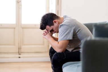 Mutsuz depresif beyaz erkek ağlama ve umutsuz hissediyorum oturma odası koltukta yalan oturan vurguladı yalnız bir iş, işsizlik, anksiyete kalbi kırık ve depresyon üzüntü kavramı.