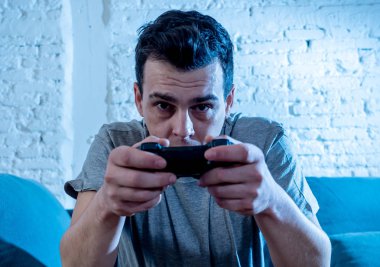 Genç öğrenci adam harcama zaman ucube yoğun mutlu yüz erkek oyun bağımlılığı konsol oyun İstasyonu ve video having oyunculuk ile kablosuz uzaktan joystick kullanarak video oyunları oynarken portresi.