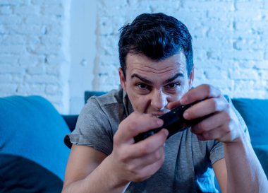 Genç öğrenci adam harcama zaman ucube yoğun mutlu yüz erkek oyun bağımlılığı konsol oyun İstasyonu ve video having oyunculuk ile kablosuz uzaktan joystick kullanarak video oyunları oynarken portresi.