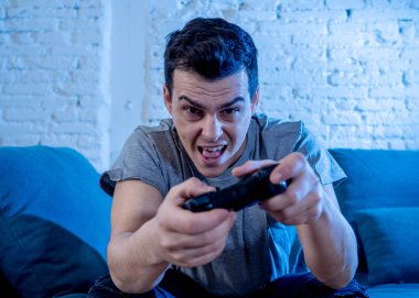 Genç öğrenci adam harcama zaman ucube yoğun mutlu yüz erkek oyun bağımlılığı konsol oyun İstasyonu ve video having oyunculuk ile kablosuz uzaktan joystick kullanarak video oyunları oynarken portresi.