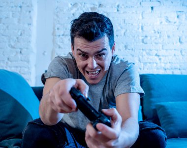 Genç öğrenci adam harcama zaman ucube yoğun mutlu yüz erkek oyun bağımlılığı konsol oyun İstasyonu ve video having oyunculuk ile kablosuz uzaktan joystick kullanarak video oyunları oynarken portresi.
