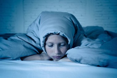 Sevimli küçük beyaz kız duygu yorgun ve uykusuz uykusuzluk depresyon stres çocuklar duygusal ve uyku bozuklukları kavram acı battaniye ile kafasını kapsayan yatakta yalan.