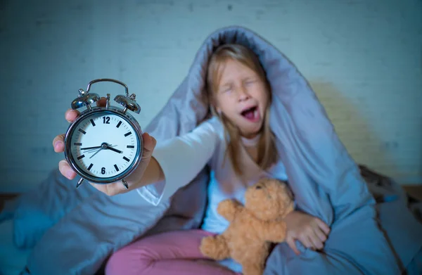 Menina Sem Sono Bonito Sentado Cama Mostrando Despertador Olhando Cansado — Fotografia de Stock