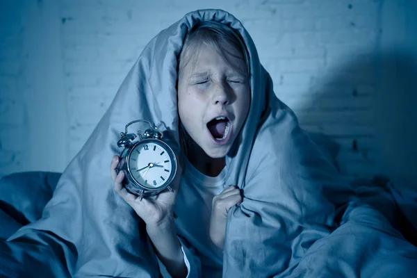 可爱的不眠之夜小女孩躺在床上显示闹钟看起来累了 晚上睡觉有困难 晚上睡觉或醒得太早 在儿童失眠和睡眠障碍 — 图库照片