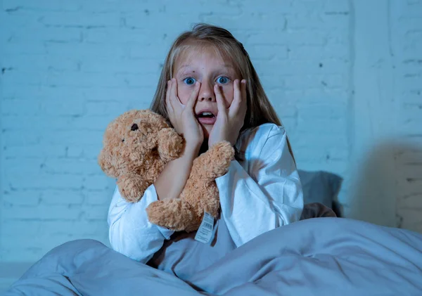 Налякана Маленька Дівчинка Сидить Ліжку Прикриваючи Обличчя Руками Тримаючи Плюшевою — стокове фото