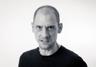 Kızgın ve üzgündüm genç adam öfkeli, agresif ve çılgın insanlar ve insan duyguları, yüz ifadeleri ve küfür, şiddet ve zorbalık kavramı bakan portresi. Beyaz arka plan üzerinde izole.