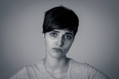 Güzel genç üzücü kafkas kadın sefil ve melankolik depresyon siyah beyaz portre. İnsan yüz ifadeleri ve duygular kavramı. Gri arka plan