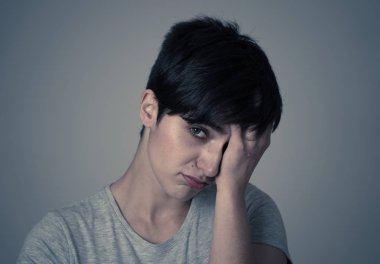 Üzgün yüz ile güzel bir genç beyaz kadın portresi kapatın. sefil ve melankoli arıyorum. İnsan yüz ifadeleri ve duygular, depresyon ve metal sağlık kavramı. Gri arka plan
