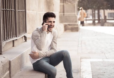 Söz ve akıllı telefon üzerinde sosyal medya arkadaşıyla tatil günlerinde Avrupa'da sohbet mutlu onun yirmili genç çekici adam. İletişim, teknoloji internet ve yaşam tarzı konsepti.