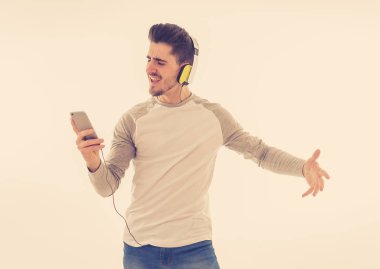 Müzik şarkı ve smartphone ve şarkı ve dans parça değiştirme Kulaklığımda mutlu genç adam portresi. İzole beyaz arka plan. Olumlu duygular, gençlik mutluluk kavramı.