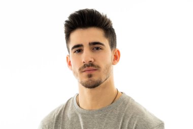 Çekici, portresi bakarak tarafsız, rahat ve ciddi insanlar yüz ifadeleri, insan duyguları, başarı ve eğitim kavramı kendine güvenen genç adam kapatın. Gri arka plan üzerinde izole.