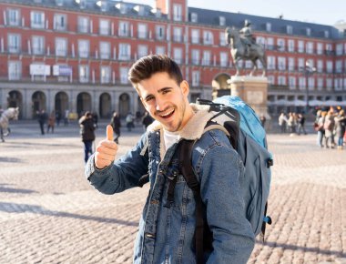 Genç turizm öğrenci adam onun yirmili mutlu ve heyecanlı hareket yukarı Plaza Mayor, Madrid, İspanya, gösterilen eğleniyor. Tatil, seyahat ve Avrupa ve özgürlük kavramı etrafında backpacking.