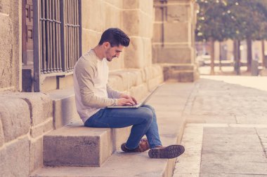 Dizüstü bilgisayar bloglama üzerinde çalışma, online sohbet ve e-posta bir Avrupa şehri açık havada kontrol trendy delikanlı. Öğrenci yaşam tarzı, teknoloji, eğitim ve uzak çalışma kavramı.