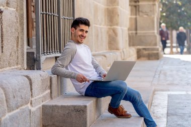 Dizüstü bilgisayar bloglama üzerinde çalışma, online sohbet ve e-posta bir Avrupa şehri açık havada kontrol trendy delikanlı. Öğrenci yaşam tarzı, teknoloji, eğitim ve uzak çalışma kavramı.