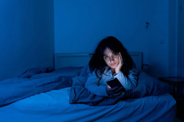 Atractiva mujer latina adicta al teléfono móvil e internet tarde en la noche en la cama buscando insomnio — Foto de Stock