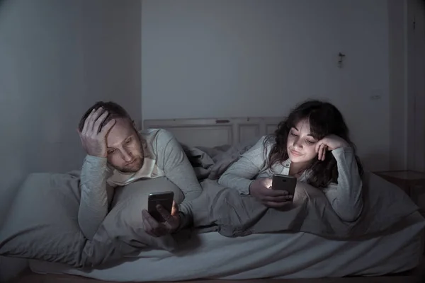 Retrato Estilo Vida Pareja Aburrida Joven Cama Por Noche Teléfonos — Foto de Stock